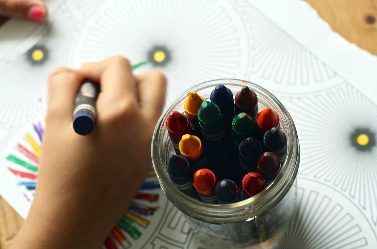 a child drawing with crayons