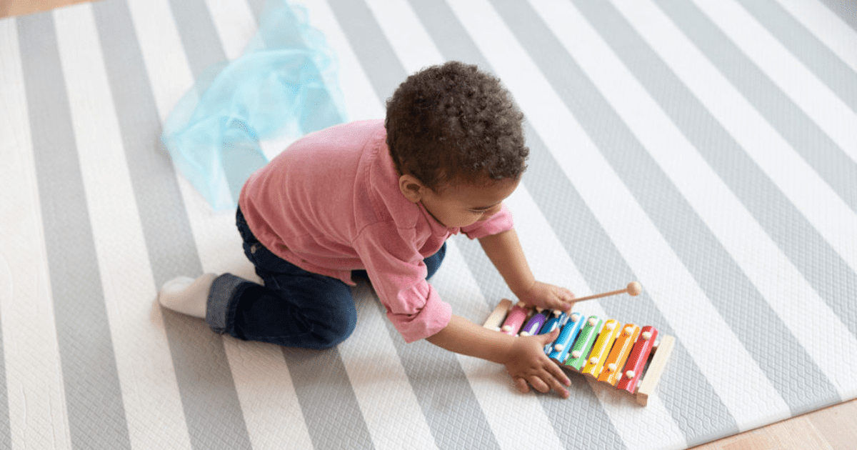 Toddler boy playing with musical instrument