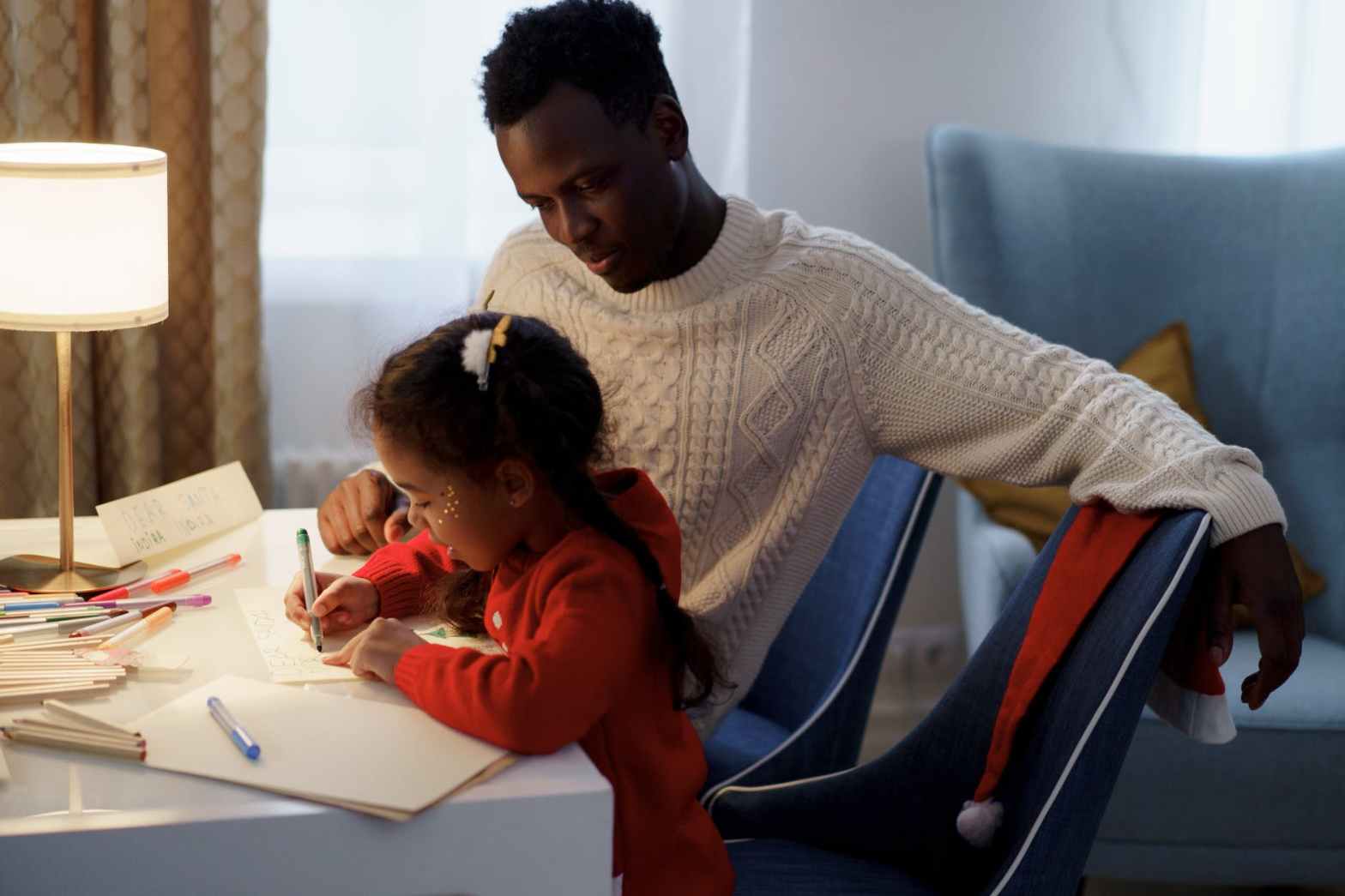 dad watching her daughter make a card